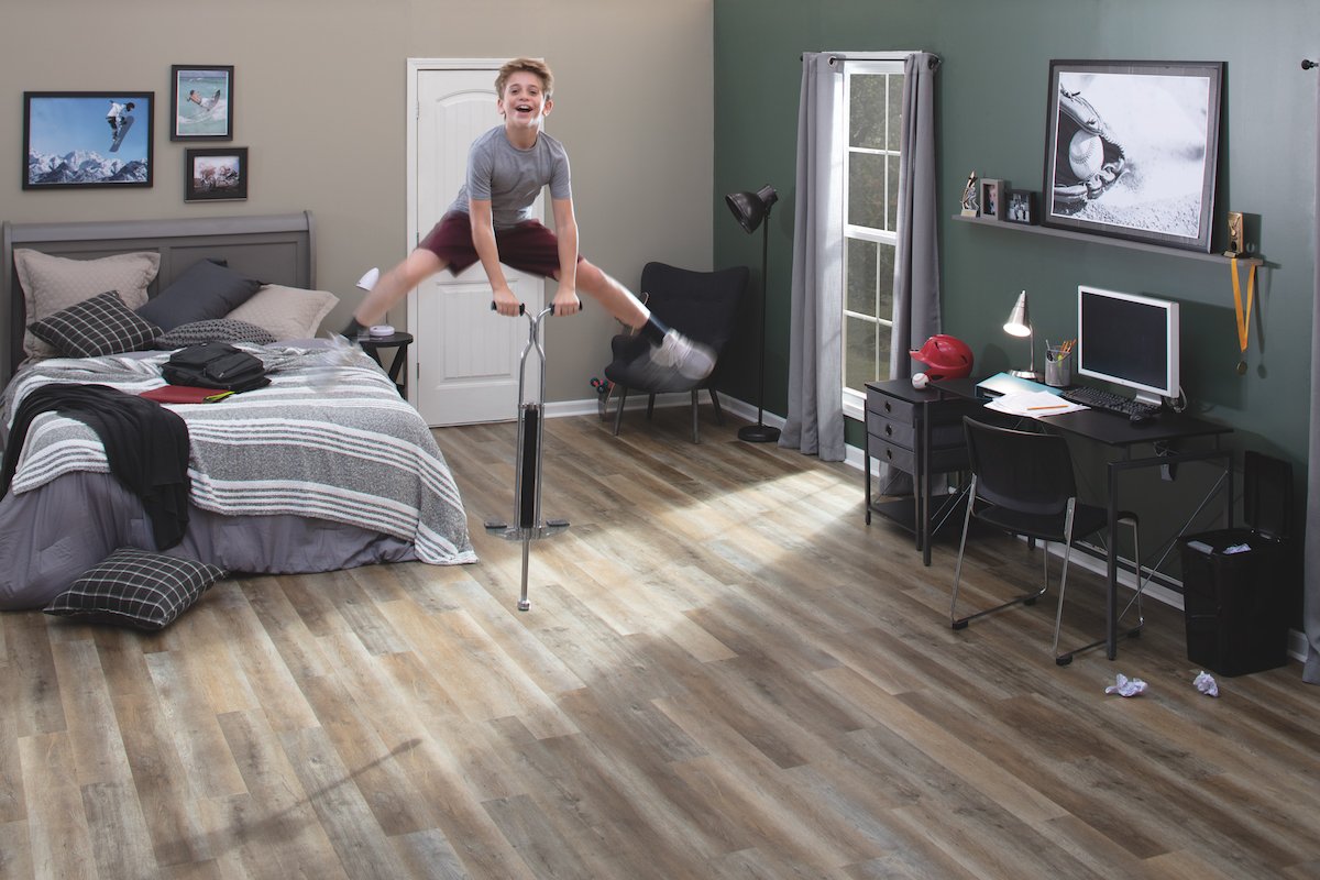 child on pogo stick in bedroom with hardwood floors